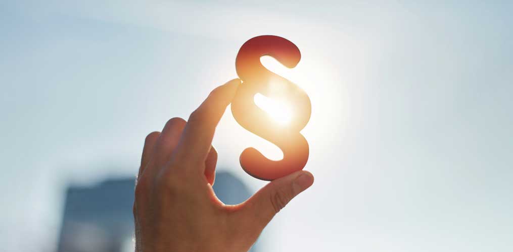 Hand holding a paragraph symbol in the sun